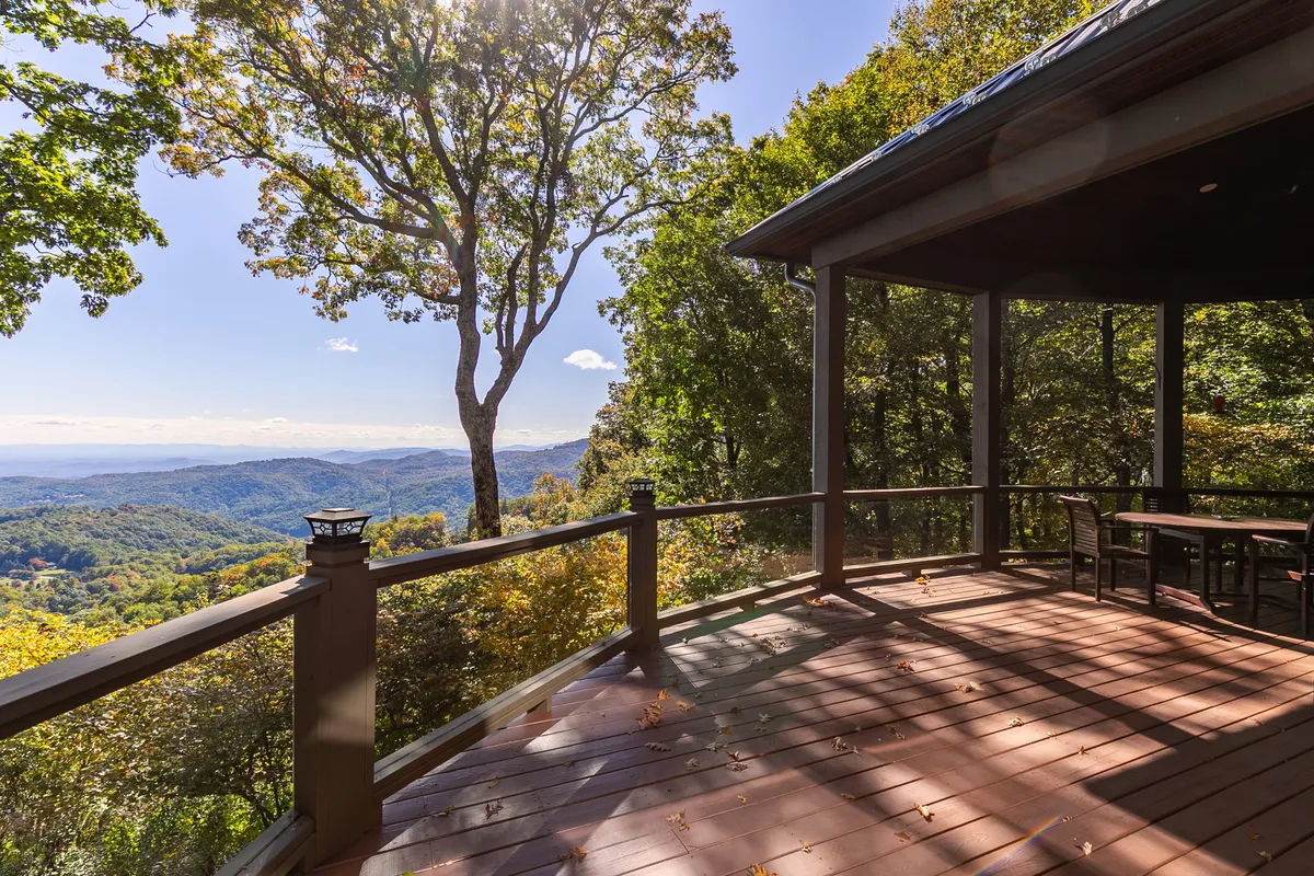 A spacious deck overlooks an expansive mountain view, with a large tree accentuating the connection to the great outdoors. The open sky and distant ridges suggest endless possibilities for exploration and relaxation, while the deck offers a comfortable place to soak in the sunrise, spot wildlife, or stargaze at night.