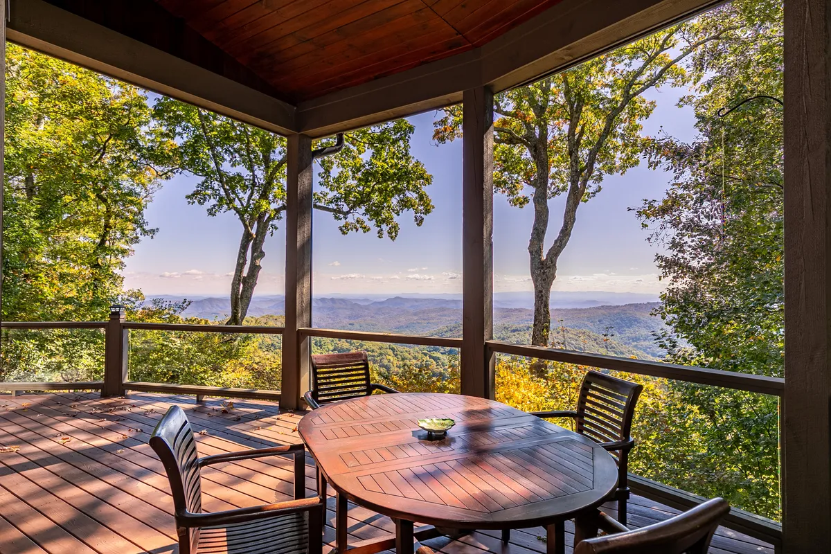 An exterior shot of a wooden dining table set amidst surrounding trees, with sweeping mountain views in the background. The setting is tranquil—ideal for taking breaks, brainstorming, or simply recharging in nature.